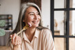 © Drobot Dean - Woman sitting at kitchen indoors at home while eating salad.