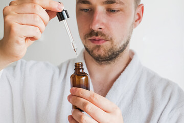 Young handsome man going to apply skin care product on his face.