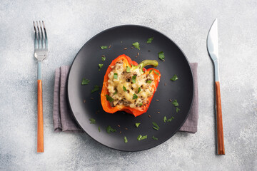 Wall Mural - Stuffed sweet peppers with rice mushrooms and cheese with herbs. Baked halves of red pepper with filling. Grey concrete background. Copy space,