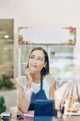 Wall Mural - Portrait of smiling young Vietnamese cafe owner dreaming about developing her business