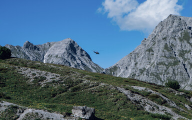 Helicopter flying over the rocky Mountains during a sunny sunset. Aerial Landscape from Austrian Alps.Panoramic nature background