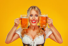 Young Sexy Oktoberfest Girl Waitress, Wearing A Traditional Bavarian Or German Dirndl, Serving Big Beer Mugs With Drink Isolated On Yellow Background. Woman Pointing To Looking Up.