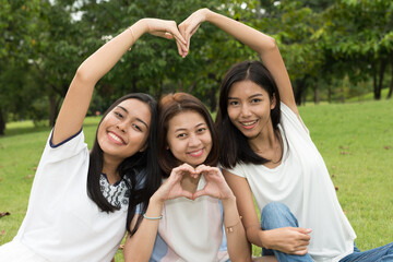 Portrait of three young beautiful Asian teenage girls as friends together at the park