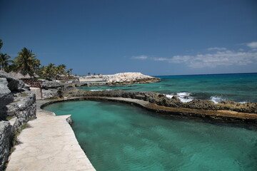 A scenic view of nature park  Xcaret with rocks and ocean under blue sky in playa del carmen Mexico