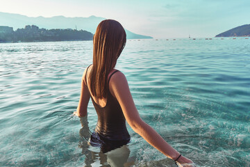 Wall Mural - Tranquility woman stands in clear turquoise calm water