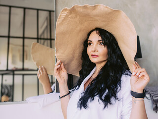 Beautiful stylish woman in straw hat at home indoor. Fashion, style, home concept