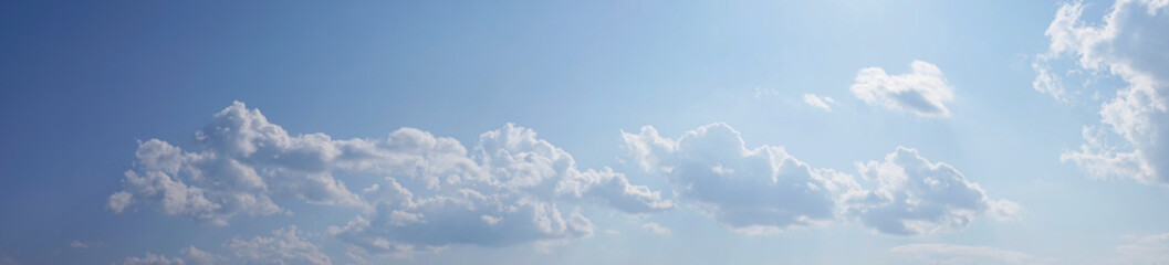 Wall Mural - white fluffy clouds on a gentle blue sky in the rays of the sun. abstract blue sky background. cloud