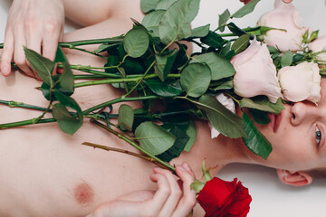 Young man model with flowers. Beauty boy portrait