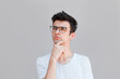 © Яна Солодкая - Young man with white shirt having doubts and with confuse face expression while scratching head on isolated grey background