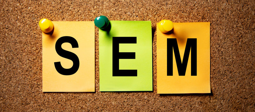 On multicolored stickers attached to a cork board is the inscription SEM.