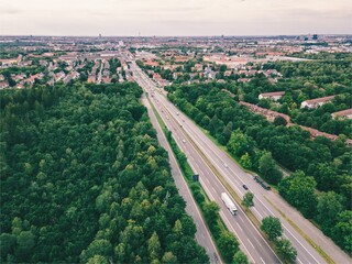 Wall Mural - Aerial view of a highway near a forest. Many cars drive to the city of Munich