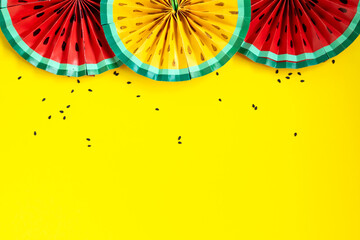 Paper fruit origami watermelon fan decoration. Creative banner with copy space on bright yellow background. Tropics summer