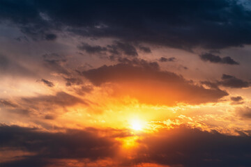 Wall Mural - Bright dramatic sunset sky background. Beautiful colorful cloudscape with sun light.
