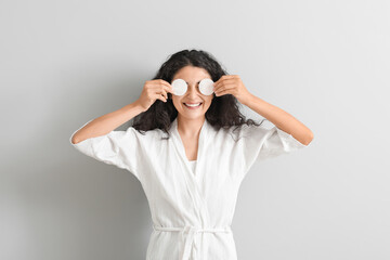 Wall Mural - Beautiful young woman with cotton pads on light background