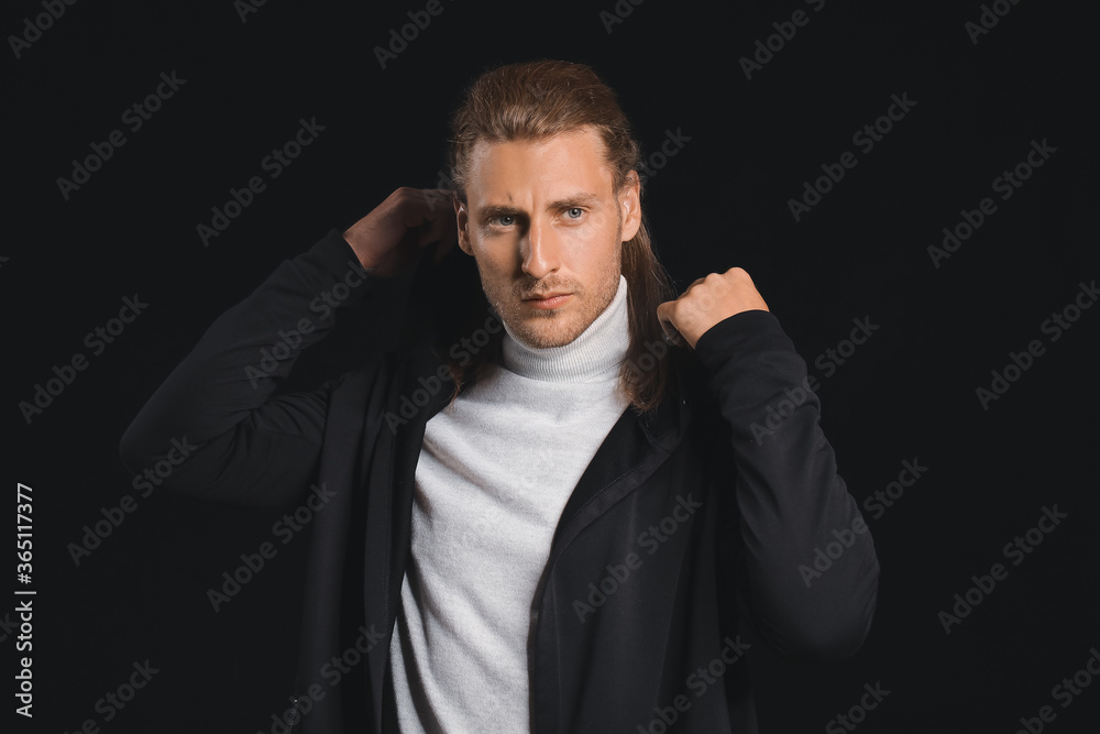 Handsome man with stylish hairdo on dark background