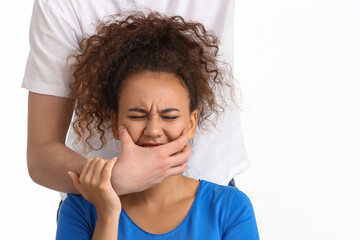 Man covering mouth of African-American woman on white background. Stop racism