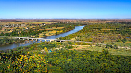 Wall Mural - Autumn view from a height of the village and the river with a bridge