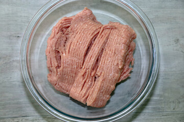 Wall Mural - Top view of two pounds of 93% lean raw ground turkey in a glass bowl.