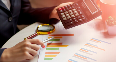 Poster - Business woman hand with Financial charts and calculator on the table