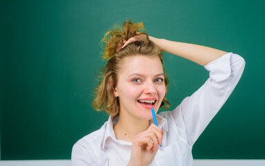 Happy smiling young teacher with pen. Smiling teacher holds pencil. Teacher in classroom. School subjects. Back to school. Portrait of female teacher with pencil. Pen. Pencils. Education. School. Job.