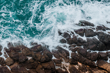 Wall Mural - aerial view of crashing waves on rocks.