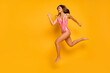 Full length body size view of her she nice attractive gorgeous chic cheerful slim slender sporty lady jumping running fast having fun isolated bright vivid shine vibrant yellow color background