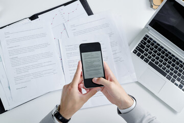 Poster - Above view of unrecognizable lawyer using smartphone while photographing contract papers on table
