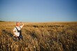 © Serhii - Serious gray haired agronomist or farmer using a tablet while inspecting organic wheat field before the harvest. Back lit sunset photo.