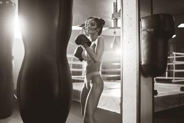 Wall Mural - Woman hitting punching bag, black and white.