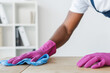 © LIGHTFIELD STUDIOS - Cropped view of african american worker of cleaning service cleaning office table