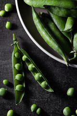 Fresh homegrown green peas in moody dark photography