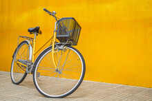 A Yellow Retro Bicycle Parking Against Yellow Wall