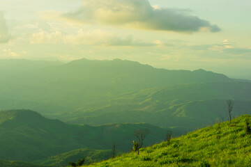 Wall Mural - sunset and mountains interspersed with green grass