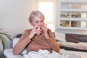 Senior Woman is having allergies and she is using nasal spray to help herself. Elder woman using nasal spray. Nasal spray to help a cold. Sick with a rhinitis woman dripping nose applies nasal spray