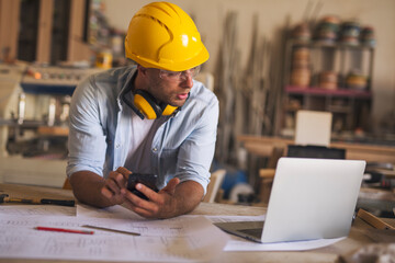 Woodworker using modern technology in a carpentry workshop