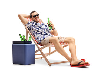 Wall Mural - Tourist with a bottle of beer on a deckchair with a cooling box beside him