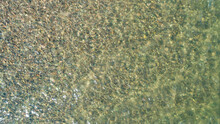 View Of Multicolored Pebble Of Sea Beach Under Clear Water. Pattern Of Sea Stone Texture Under Water. Sea Bottom With Pebbles Through Clear Water. Natural Background.