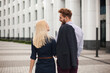 © Studio Peace - Rear view of young couple man and woman looking at each other. The white building in the background.