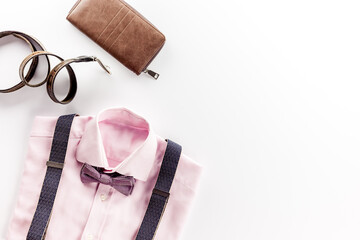 The concept of men's clothing. Pink shirt with bow-tie and suspenders on White background top view flat lay copy space