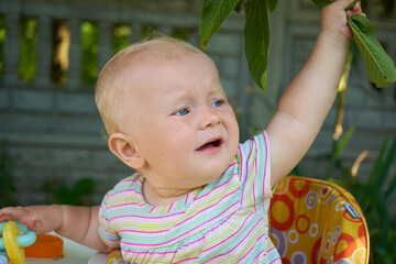 baby crying in a walker,saddened baby in a walker crying in the yard