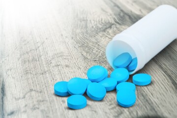 Poster - Medical colored pills in the plastic bottle on the desk