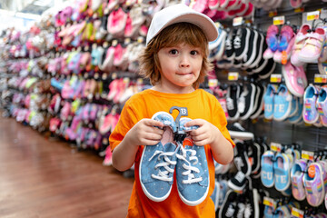 Wall Mural - Customer child holdind shoes, shopping at supermarket, kids shoes store.