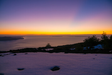 rays of light cross the sky with beautiful colors, after sunset in the snowy mountains