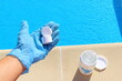© Sagittarius_13 - White mini chlorine tablet in the hand of a service worker for disinfection of swimming pools. The beginning of the swimming season is hot summer.