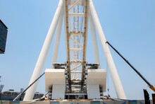 Dubai, United Arab Emirates. Construction Site Of Dubai Eye (Ain Dubai) - The Largest Ferris Wheel In The World On Artificial Bluewaters Island, View From The Side With Crane And Machines.