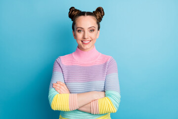 Sticker - Photo of attractive teen lady two funny buns good mood toothy white smile charming nice youngster arms crossed wear casual warm striped sweater isolated blue color background