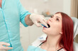 © johnalexandr - The orthodontist shows the patient an impression tray in which the silicone impression material will be placed to get the shape of her teeth