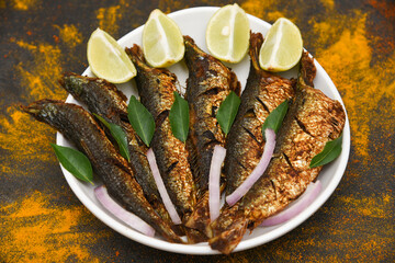 Wall Mural - Sardine fish fry or pilchard fry fish curry with salad tasty sea food cuisine, Kerala India. Popular dish in coastal area restaurant,  mathi or chala meen fry best served with rice.