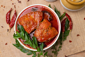 Poster - Kerala fish curry Alappuzha, India, Hot and spicy homemade red fish Masala curry on jute background. using king fish, coconut milk, gambooge, turmeric. Top view non veg Indian side dish food. 