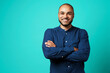© fotofabrika - Portrait of a dark-skinned cheerful smiling man against turquoise background